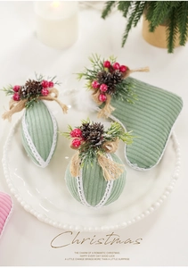 Detail view of sage green corduroy Christmas ornaments with pinecones and white lace trim