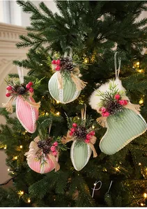 Close-up of festive velvet Christmas ornaments with pinecones, berries and linen bows