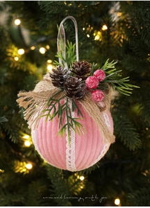 Detail of pink corduroy Christmas ball with lace, pine cones, and red berries decor
