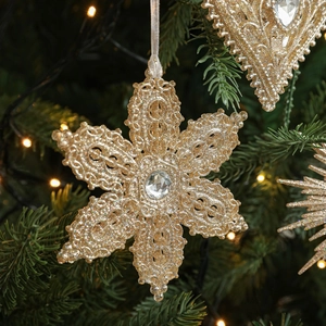 Sparkling gold snowflake ornament with large central crystal on Christmas tree