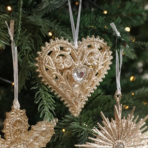 Champagne gold glitter hollow heart ornament with crystal on a decorated Christmas tree