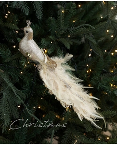 Detailed view of a golden Christmas bird ornament with long white feathers on a festive tree