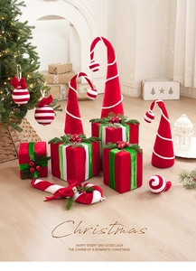 Detail of red velvet Christmas gift box and striped candy cane ornaments on wood floor