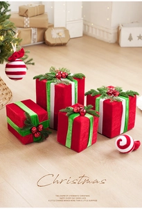 Detailed view of red velvet Christmas gift box ornaments with green silk ribbons and bells
