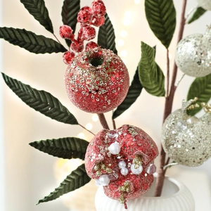 Artificial red pomegranate berry branch with glitter leaves in ceramic vase decor