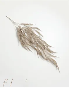 Macro detail of artificial champagne gold fern leaf branch with sparkling glitter finish