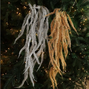 Glittery gold and silver willow branch ornaments hanging on a Christmas tree with lights