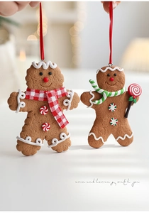 Close-up of two cute gingerbread man ornaments with colorful scarves and candy details