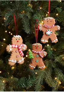 Detailed view of gingerbread man ornaments hanging on a lighted Christmas tree