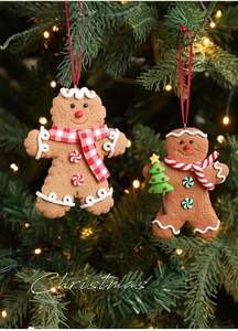 Detail of gingerbread man Christmas tree ornaments with festive scarves on a lit tree