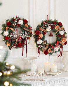 Detailed close-up of burgundy Christmas wreaths with berries, pinecones and cotton decor