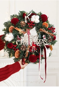 Detail of Christmas wreath with warm LED lights, red balls, pine cones and cinnamon sticks