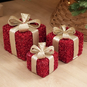 Close-up of three red glitter Christmas gift box ornaments with gold sequin bows