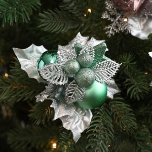 Christmas tree decoration with green ornaments and silver glitter leaves on pine branches
