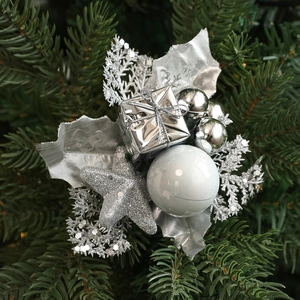 Detail of silver gift box and glitter stars ornaments on green Christmas tree branches