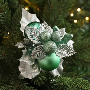 Macro detail of Christmas picks with frosted green ornaments and glitter silver leaves