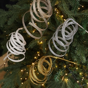 Glitzernde Spiralband-Weihnachtsanhänger am Baum in Gold, Silber und Weiß-Tönen