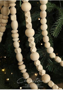 Close-up of geometric natural wood beads garland on a decorated Christmas tree