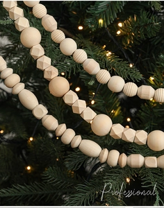 Macro shot of geometric wooden bead garland hanging on a green Christmas tree