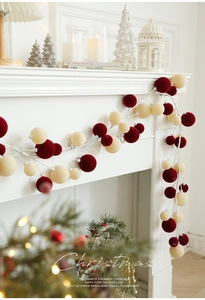 Detail of 1.8M red and cream flocked Christmas ball garland on a white fireplace mantle