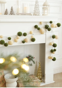Detail of 1.8M Christmas ball garland with green and cream flocked spheres on a mantel
