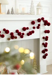 Detail of red flocked Christmas ball garland hanging on a fireplace mantel