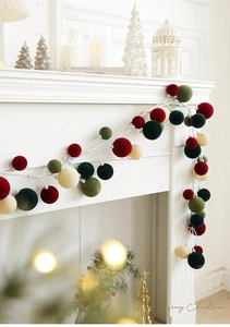 Detail of 1.8M Christmas ball garland with velvet texture on a white fireplace