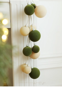 Macro view of 1.8M dark green and beige flocked Christmas ball garland for home holiday decor
