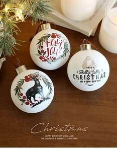 Detalle de tres bolas de Navidad blancas con estampados de renos y Papá Noel antiguos