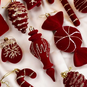 Detailed set of burgundy flocked Christmas ornaments with gold glitter on white satin