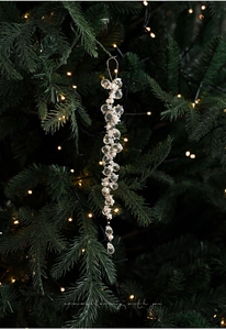 Detailed view of clear acrylic beaded icicle ornaments on a green Christmas tree branch