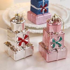 Gros plan de pendentifs boîtes cadeaux de Noël empilées avec paillettes et nœuds