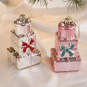 Détail de suspensions en forme de boîtes cadeaux étagées avec nœuds pailletés pour Noël