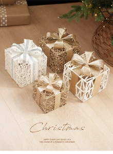 Detail of glitter ironwork Christmas gift boxes with bows on wooden floor scenery
