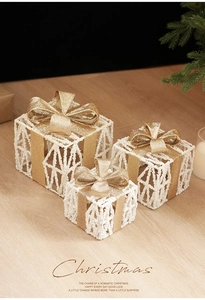 Three-piece set of white iron Christmas gift boxes with gold bows and pine cone decor