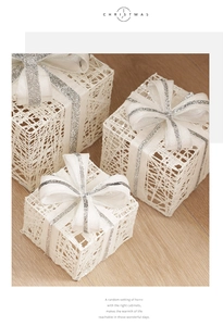 Detailed view of three white mesh Christmas gift box decorations with silver glitter bows