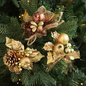 Golden Christmas berry and leaf ornaments set on a festive tree branch with warm lights
