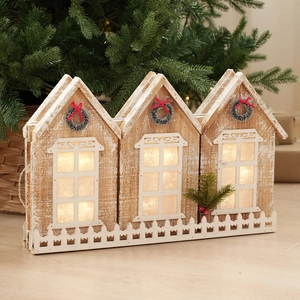 Detail of wooden Christmas house fence with warm LED lights and festive mini wreaths