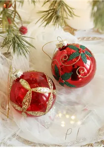 Close-up of red Christmas baubles with holly patterns and gold glitter details