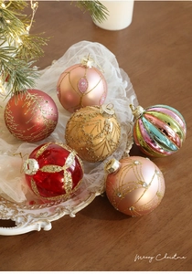 Set of six colorful 8cm Christmas glass ornaments with glitter patterns on a white tray