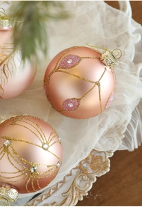 Macro detail of 8cm rose gold Christmas ball with glitter patterns and sparkling rhinestones