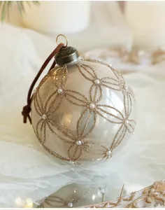 Detailed view of 8cm champagne glass ornament with gold glitter patterns and pearls