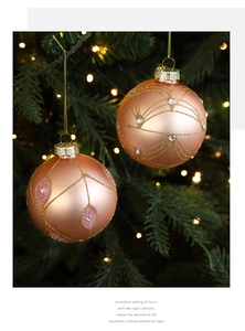 Detail of rose gold frosted glass Christmas ball with glitter lines and rhinestones