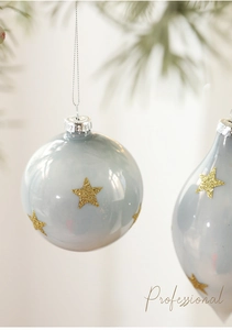 Macro detail of blue glass Christmas ornaments with golden glitter stars and silver caps