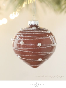 Detailed view of brown teardrop glass ornament with white glitter swirls and pearls