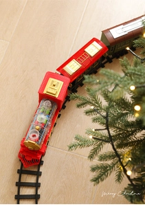 Detail of Christmas electric train set with transparent red locomotive on black tracks