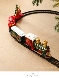 Top view of a vintage electric Christmas train set with tracks on a wooden floor