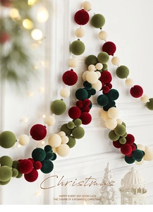 Close-up of festive velvet bauble garland with pearls against a cozy light background