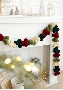 Detail of colorful velvet Christmas ball garland decorating a white fireplace mantel