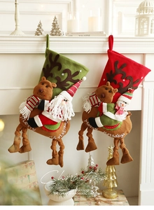 Détail de chaussettes de Noël en peluche 3D avec broderie de renne et de Père Noël
